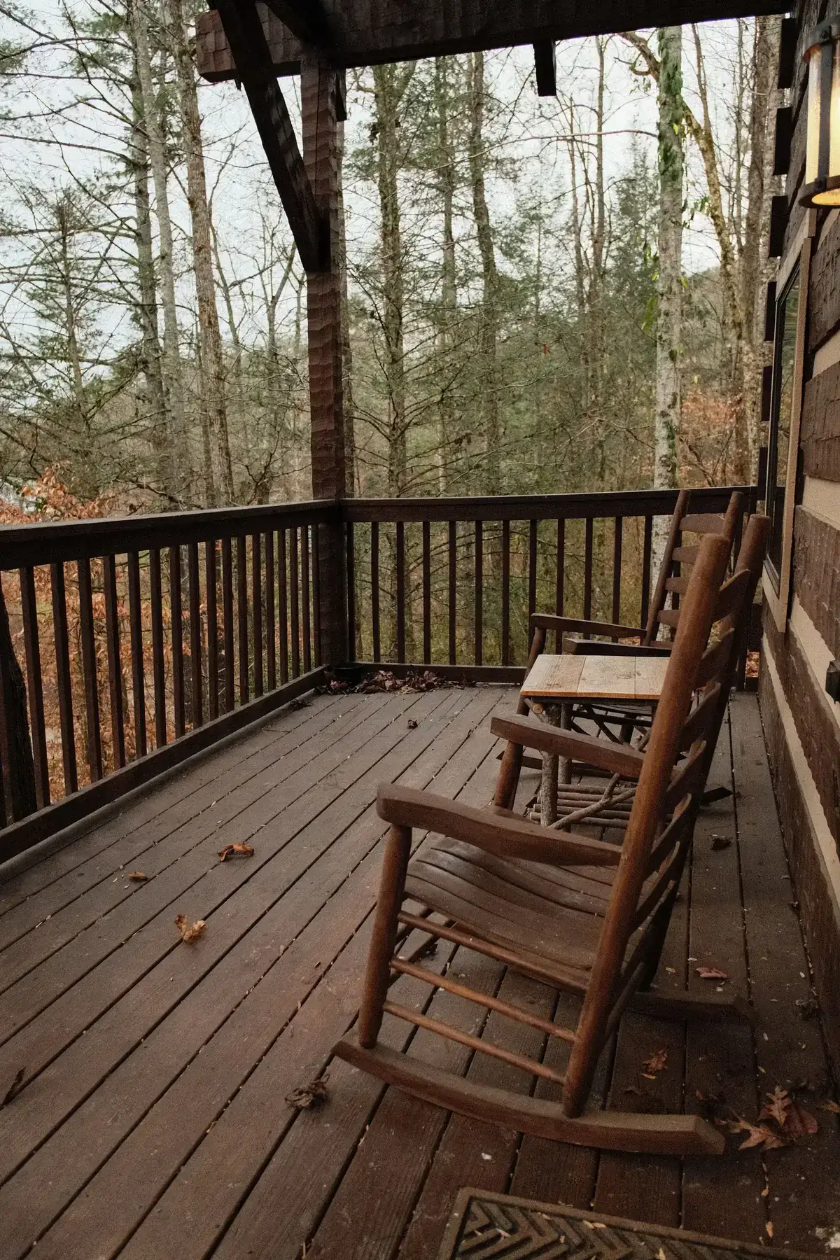 Cozy wooden deck with rustic chairs overlooking a peaceful forest in autumn