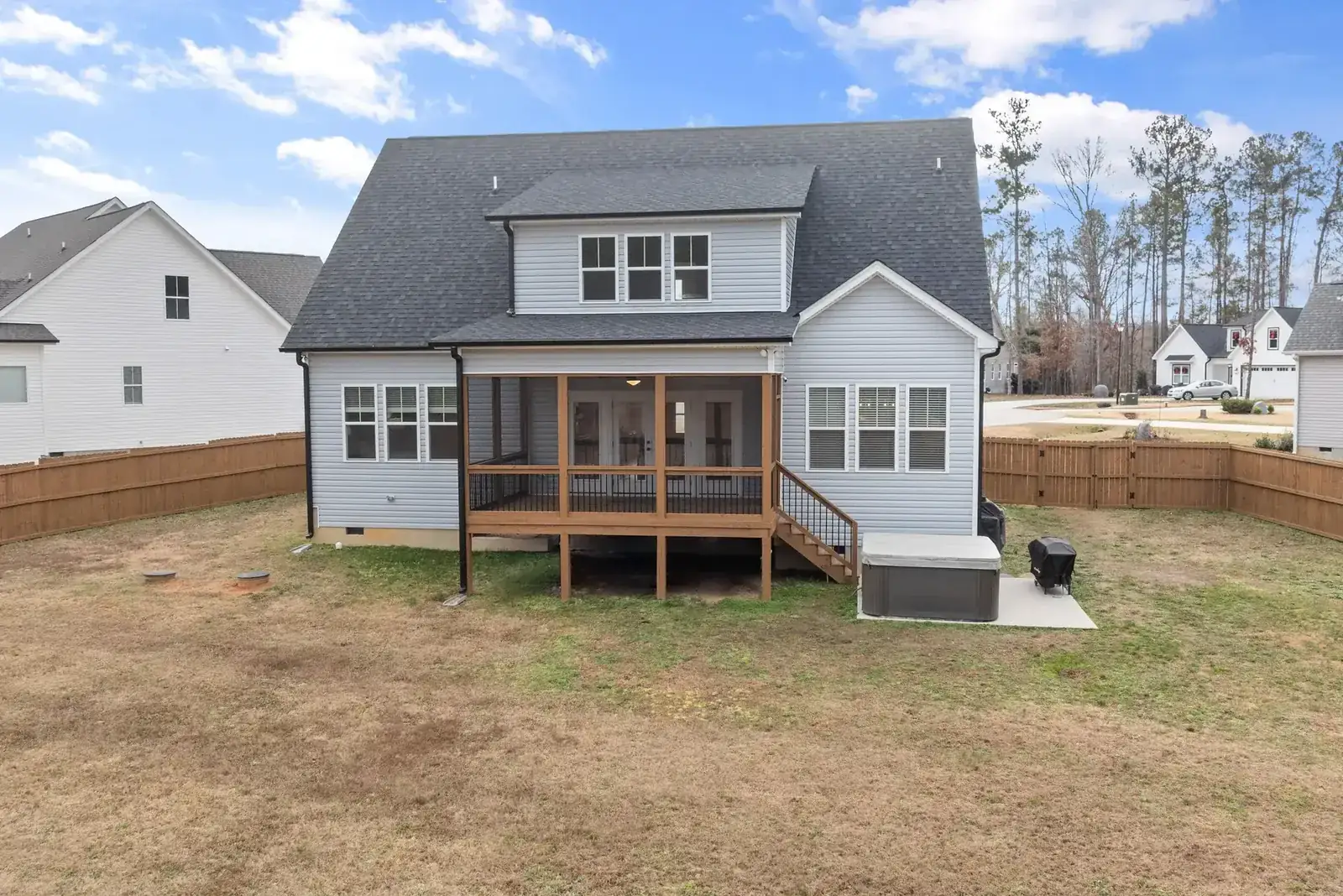 Two-story suburban home with wooden deck and fenced backyard, ideal for family living
