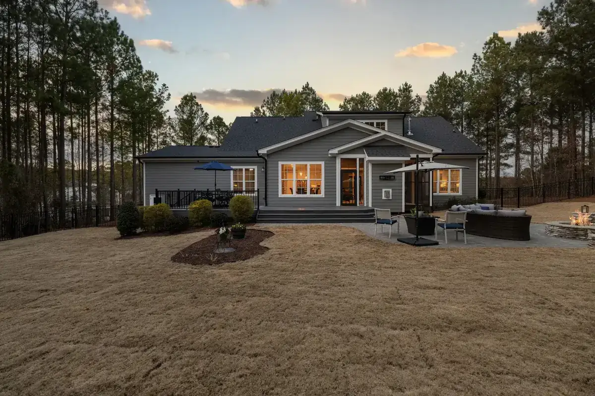 A beautiful modern house with a spacious backyard, illuminated during sunset. Ideal for lifestyle and real estate imagery