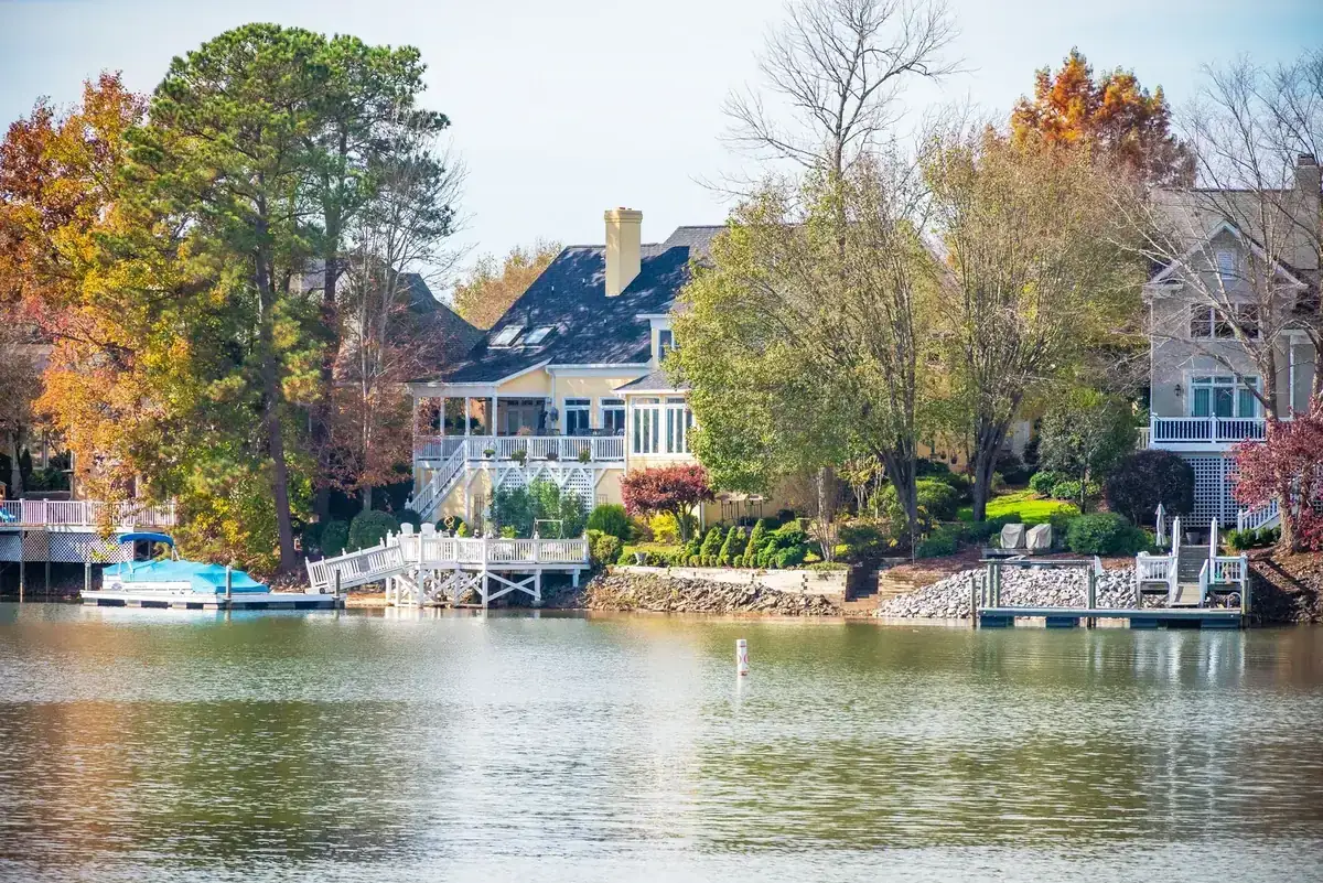 Picturesque lakeside home surrounded by vibrant autumn foliage. Ideal for real estate or travel themes