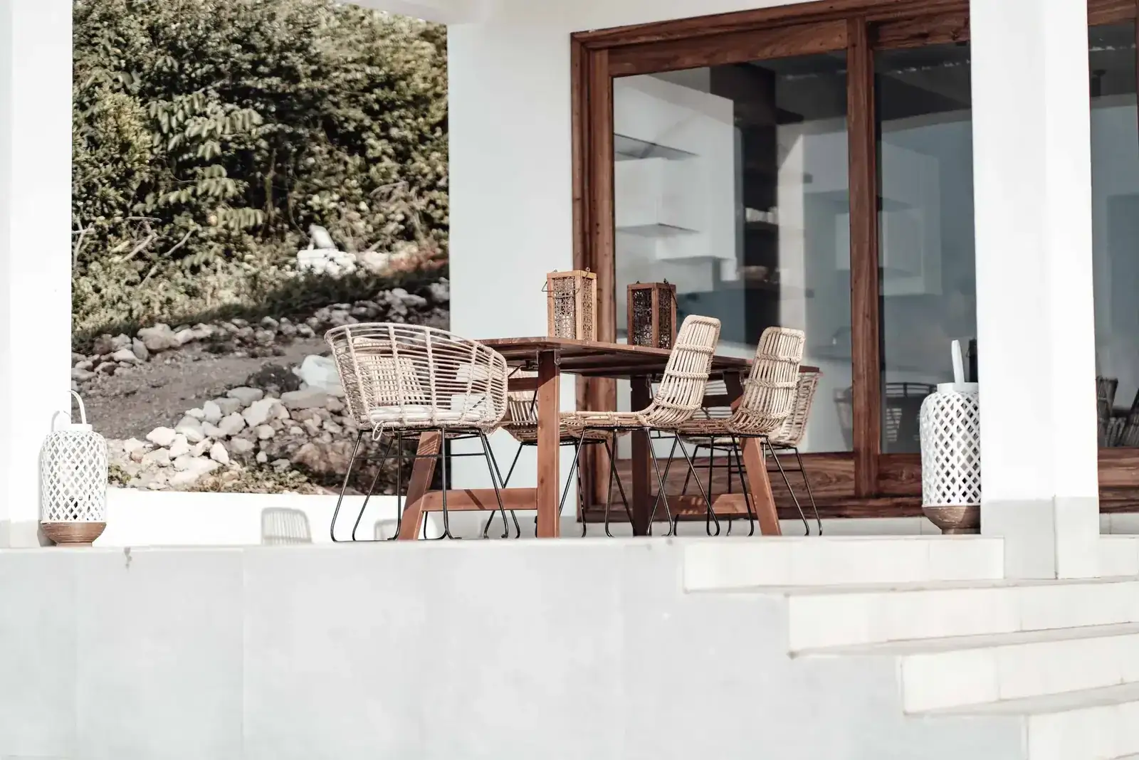 Contemporary outdoor patio featuring a wooden table and wicker chairs, perfect for relaxation