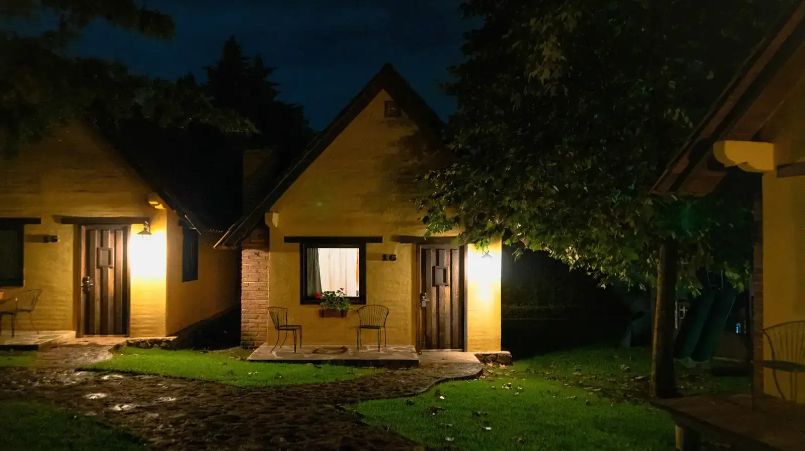 Charming yellow cottages glow warmly under twilight, offering a tranquil, scenic retreat