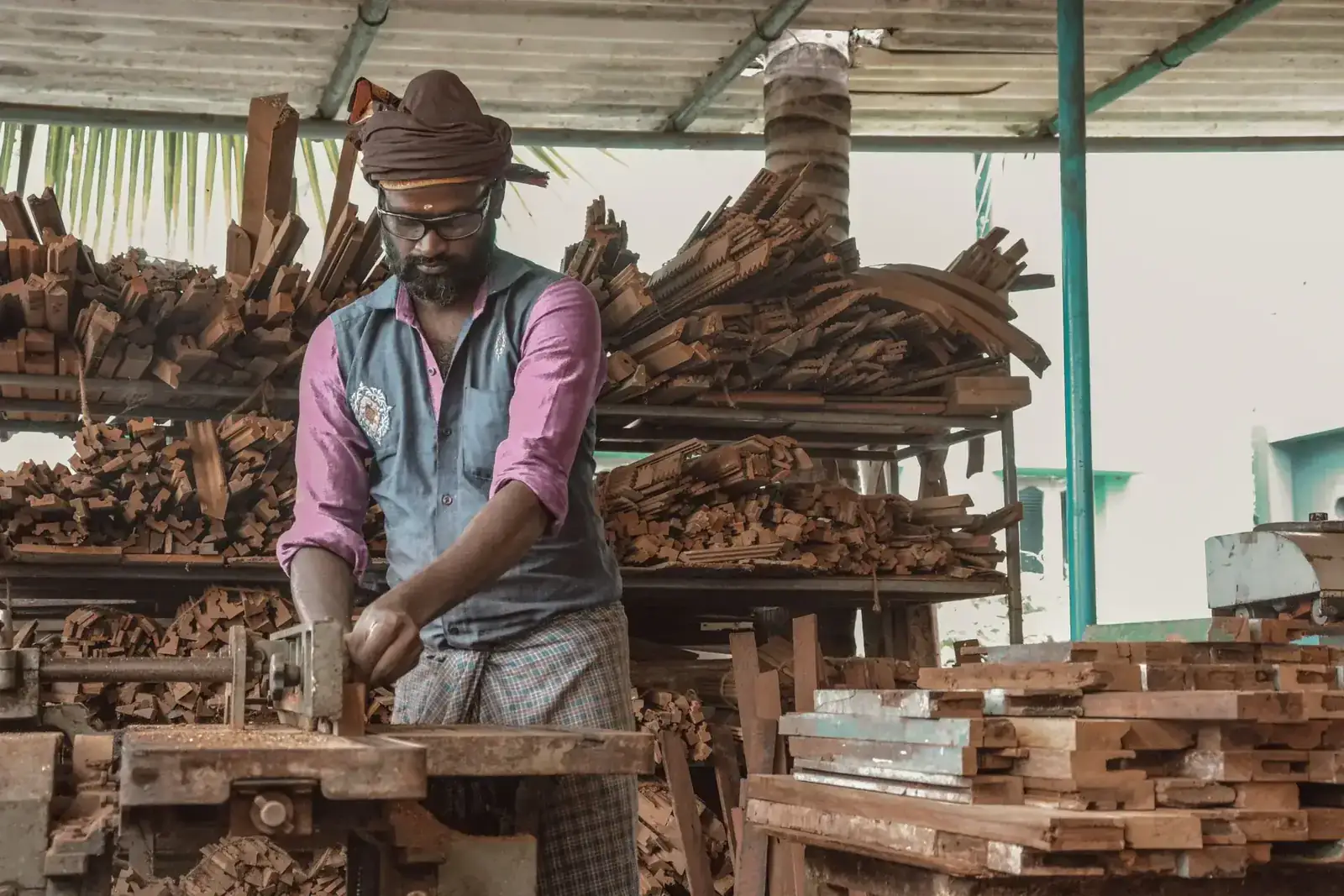 Carpenter demonstrates craftsmanship in a rustic workshop filled with wood pieces