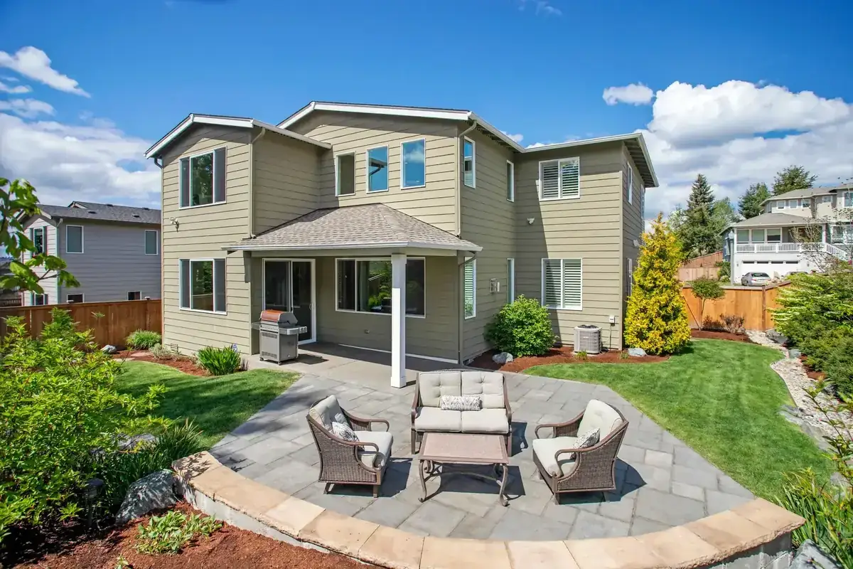 Explore a sunny suburban backyard with patio seating and landscaped garden