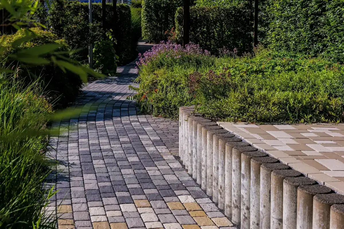 Stone garden path winding through lush greenery on a sunny day