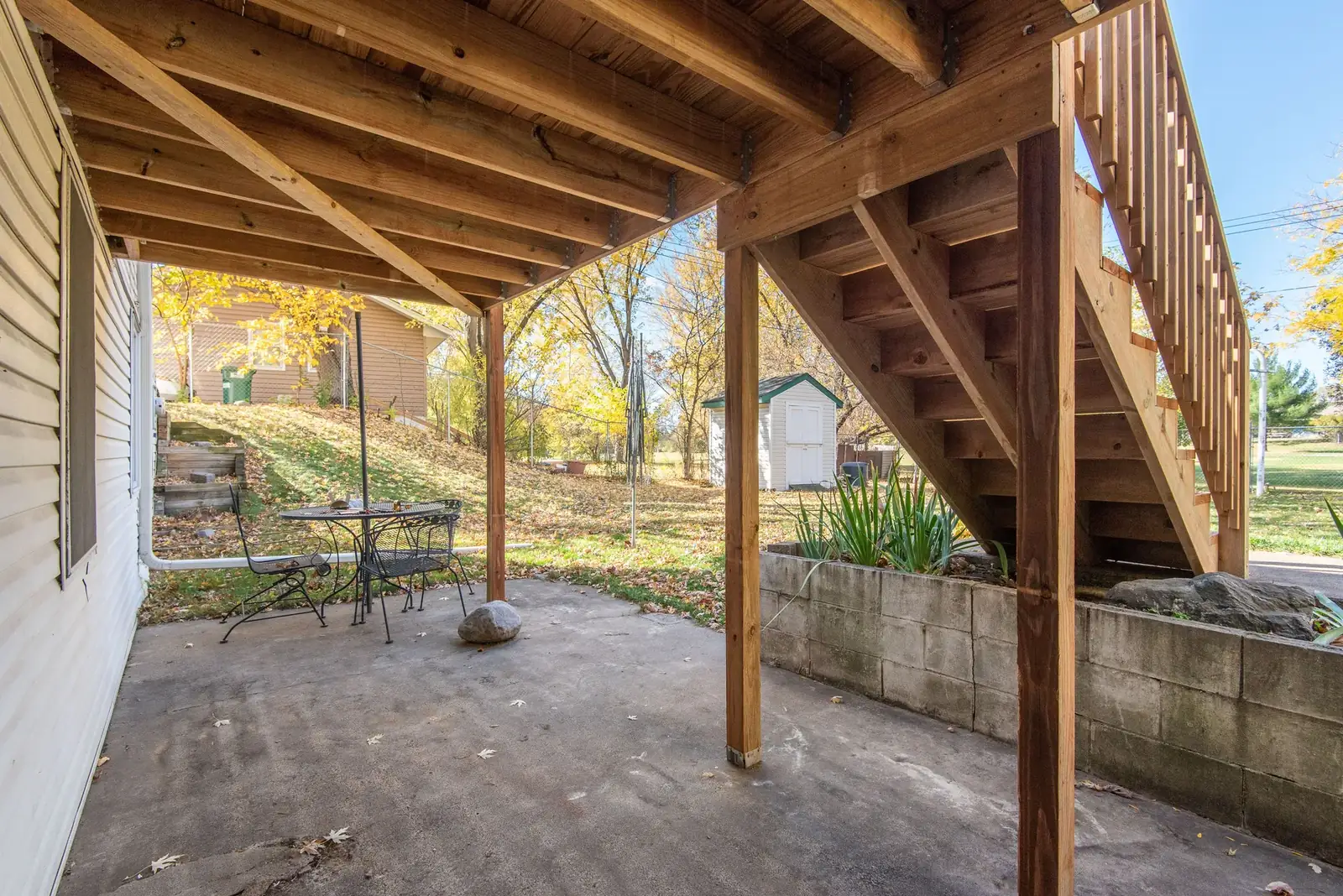 Elevated residential wood deck and stairs opening toward a wooded backyard