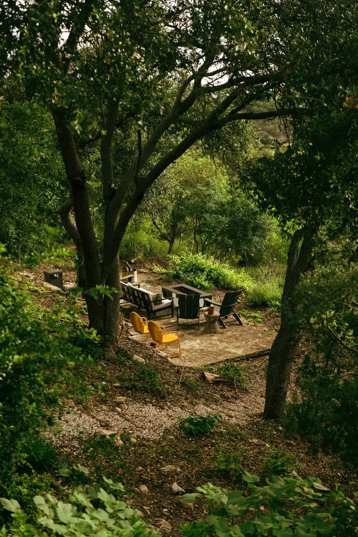 Garden fire pit surrounded by layered greenery and outdoor seating