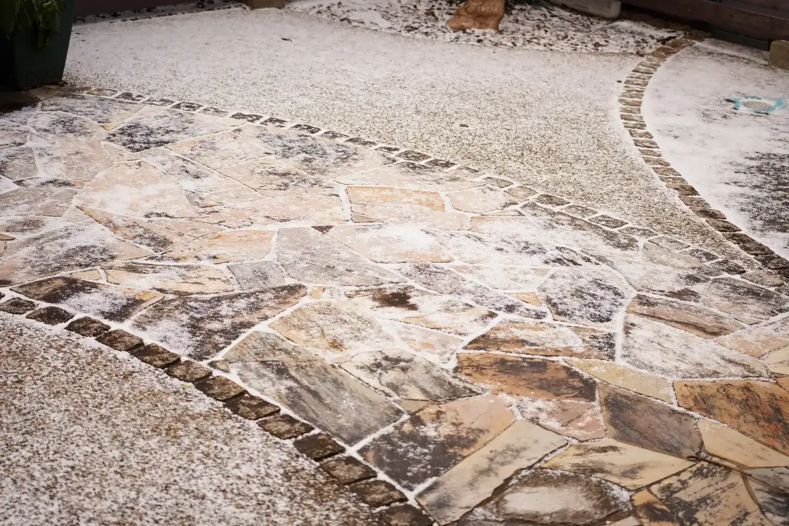 Paver patio, broad steps, and low seat wall on a wooded property