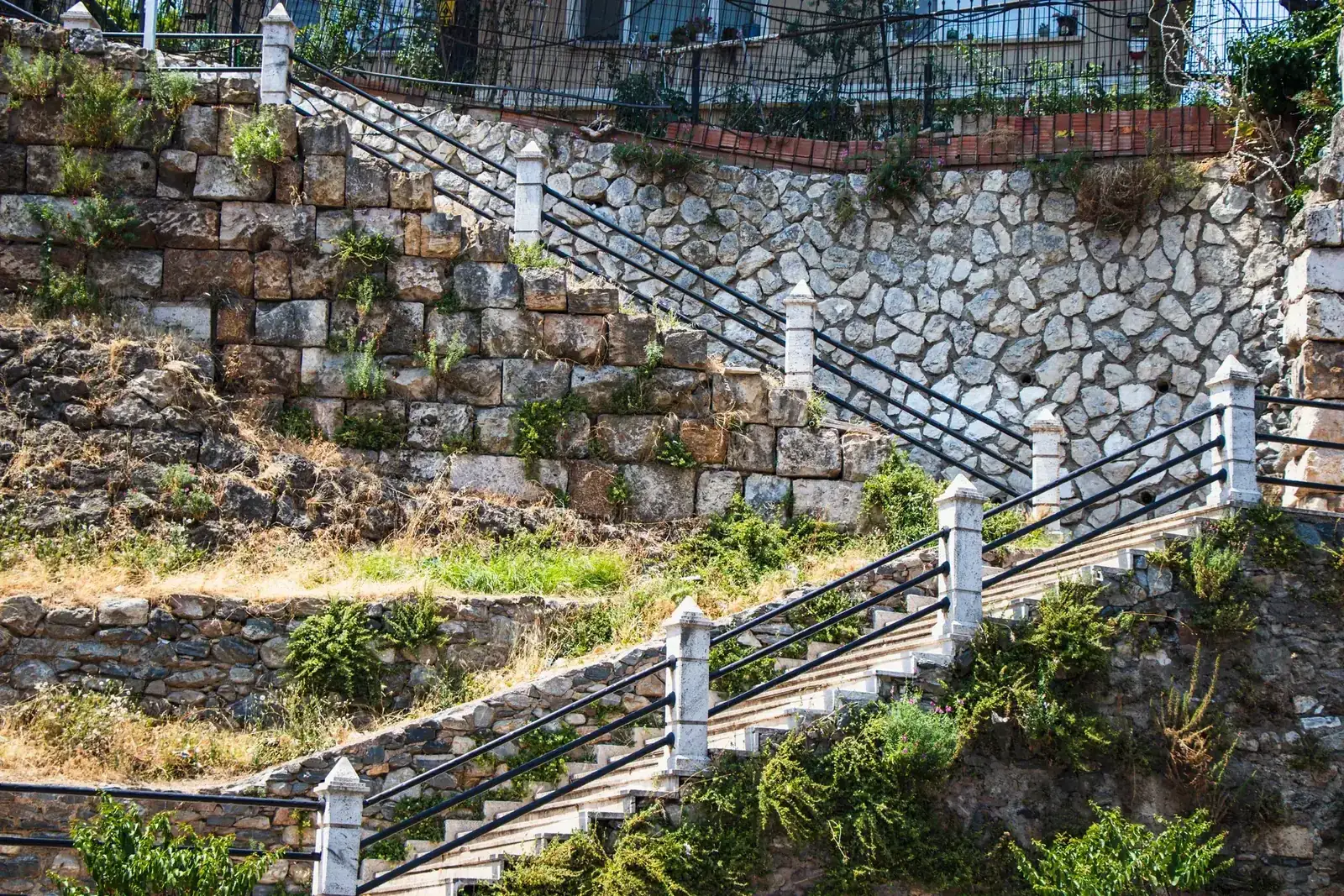 A historic stone staircase adorns a scenic outdoor hillside landscape