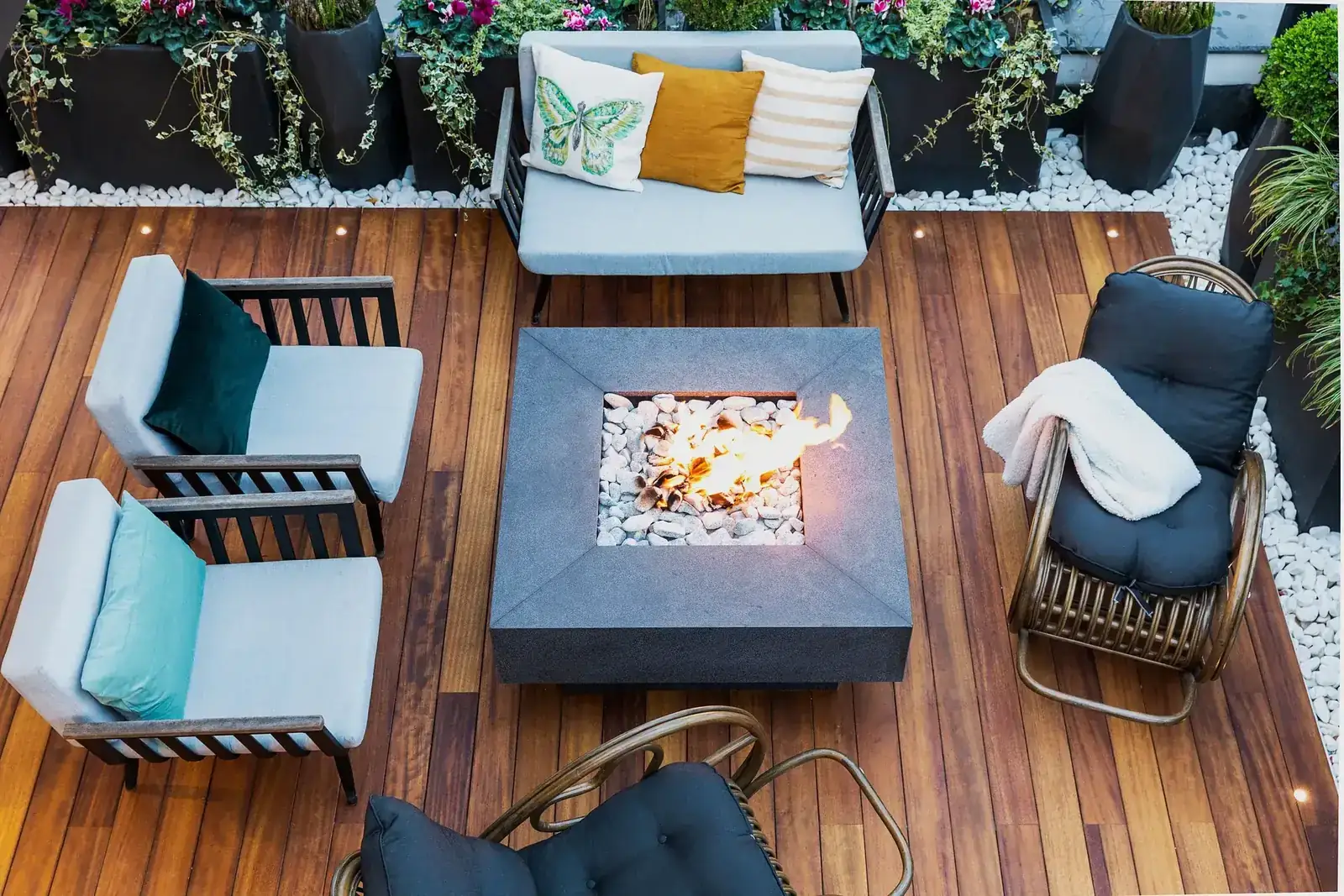 A top-down view of a modern patio featuring stylish furniture and a central firepit